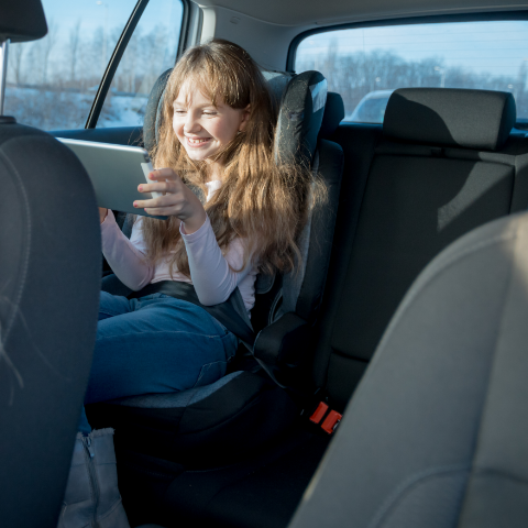 Child playing in the car on a road trip